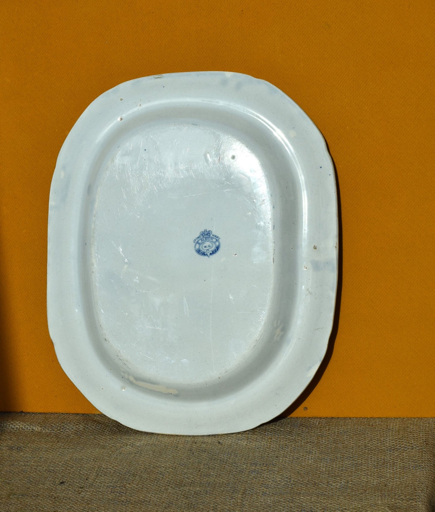 White ceramic platter with blue design on an orange background