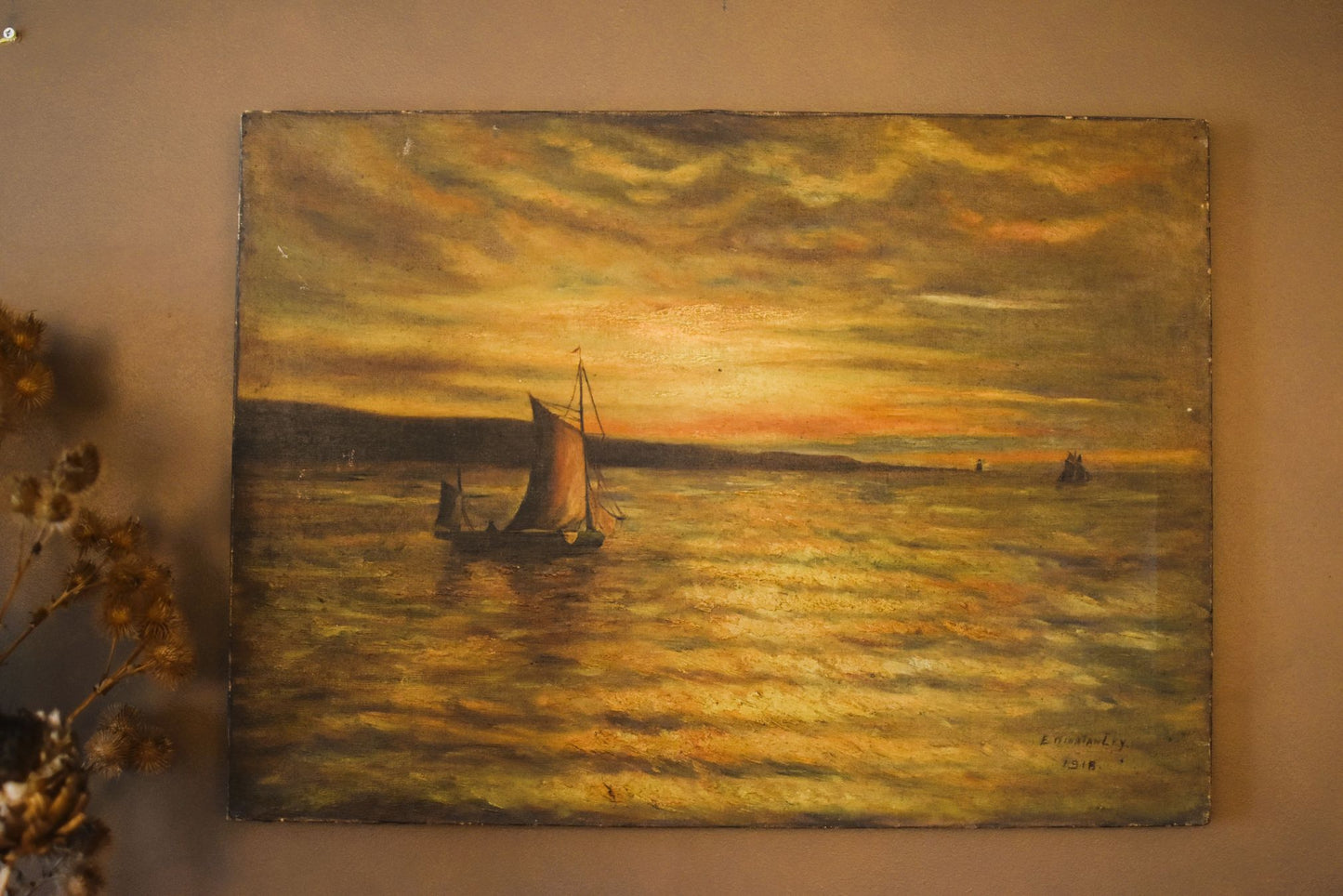 A painting in golden, yellow, orange and brown showing a calm sunset over sailing boats on the sea