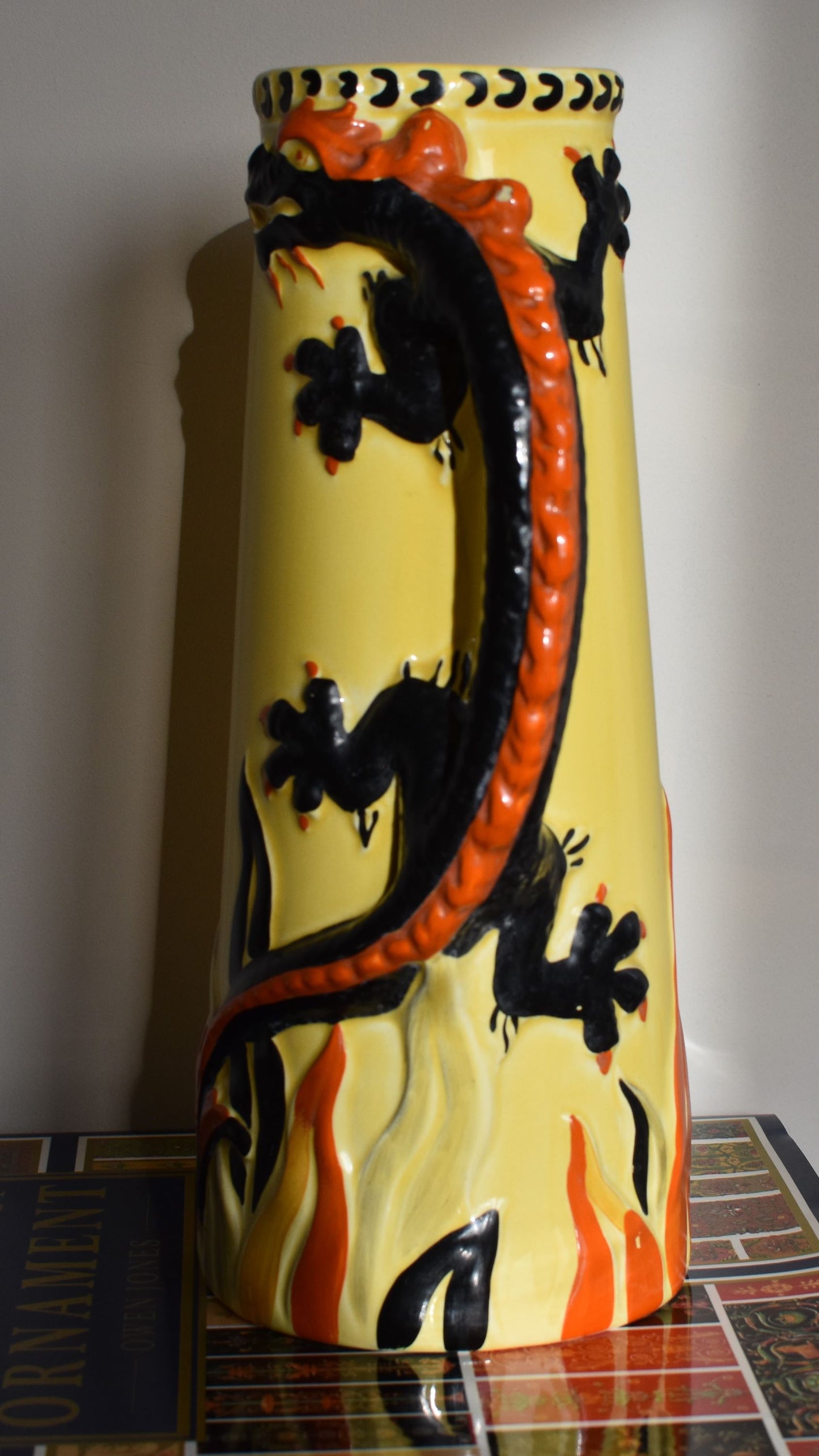 A close up of the red and black dragon which forms the handle of the jug