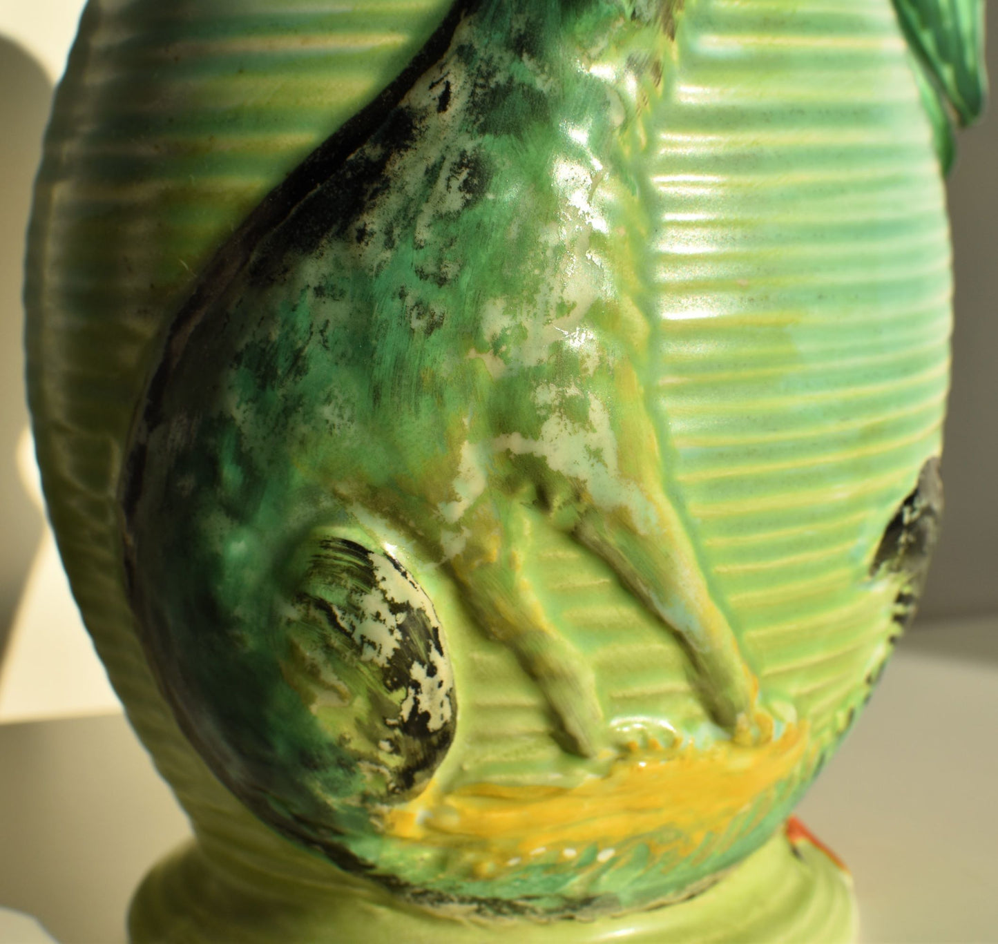 Some of the glaze on the wolf decoration has rubbed off with age and use