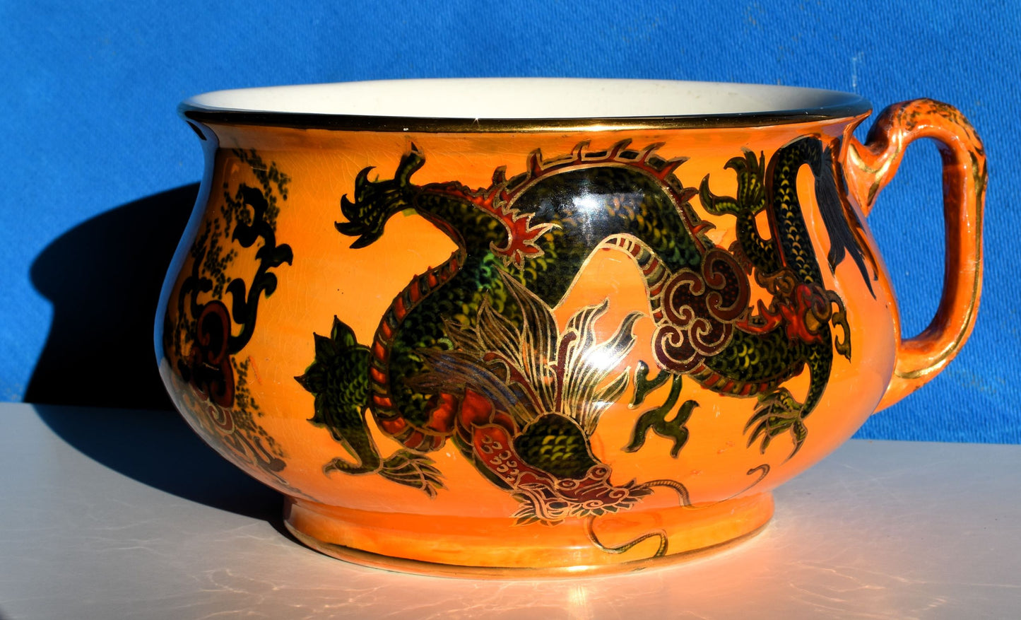 Orange chamber pot decorated with hand painted green and red dragon, all over gold details