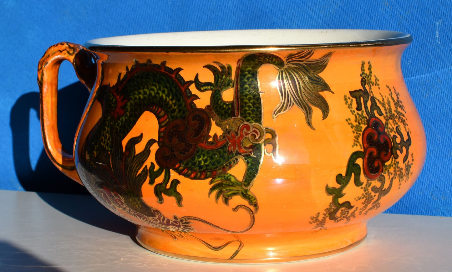 Orange chamber pot decorated with hand painted green and red dragon, all over gold details