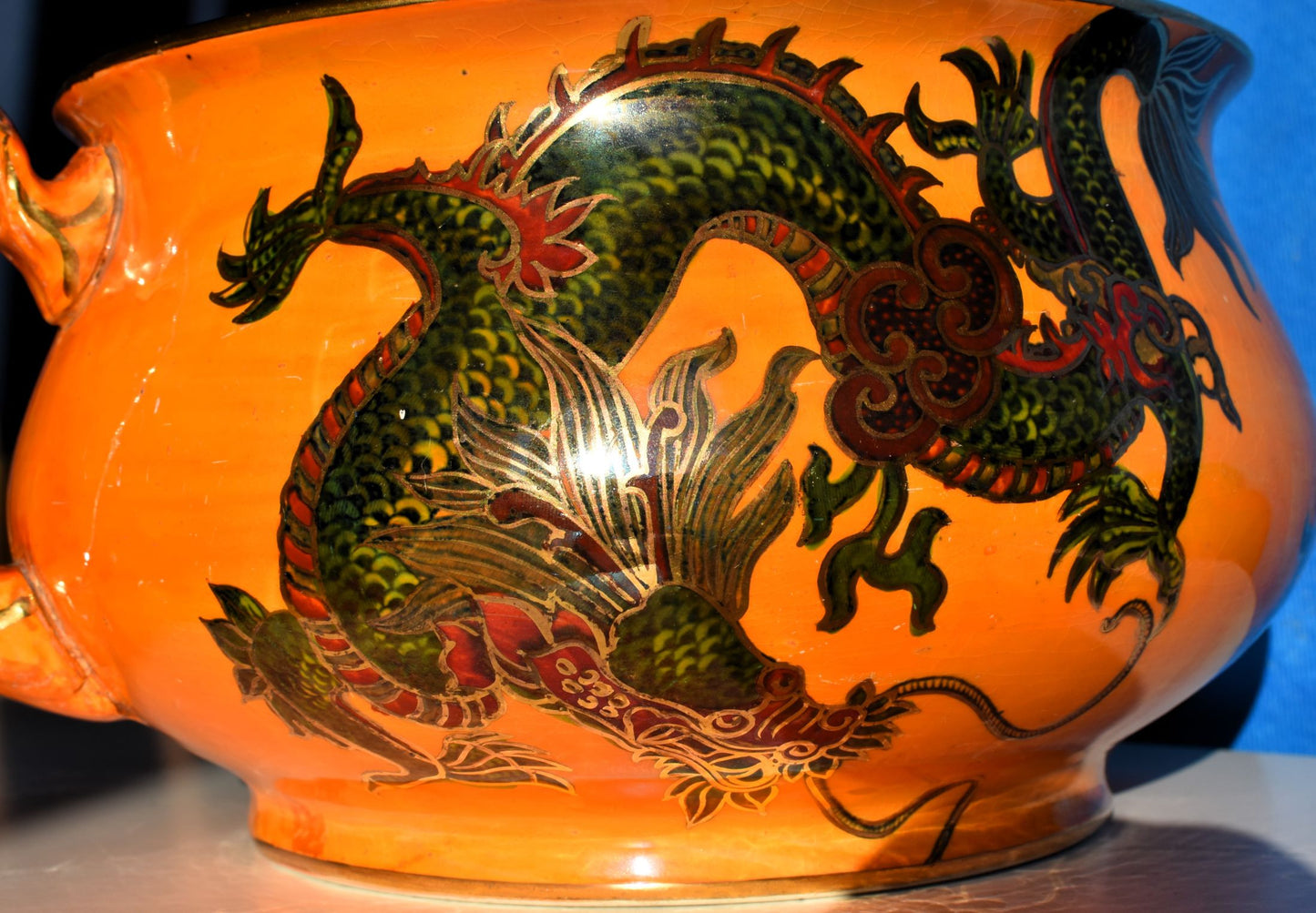 A close up of the dragon shows the intricate painting and gold relief
