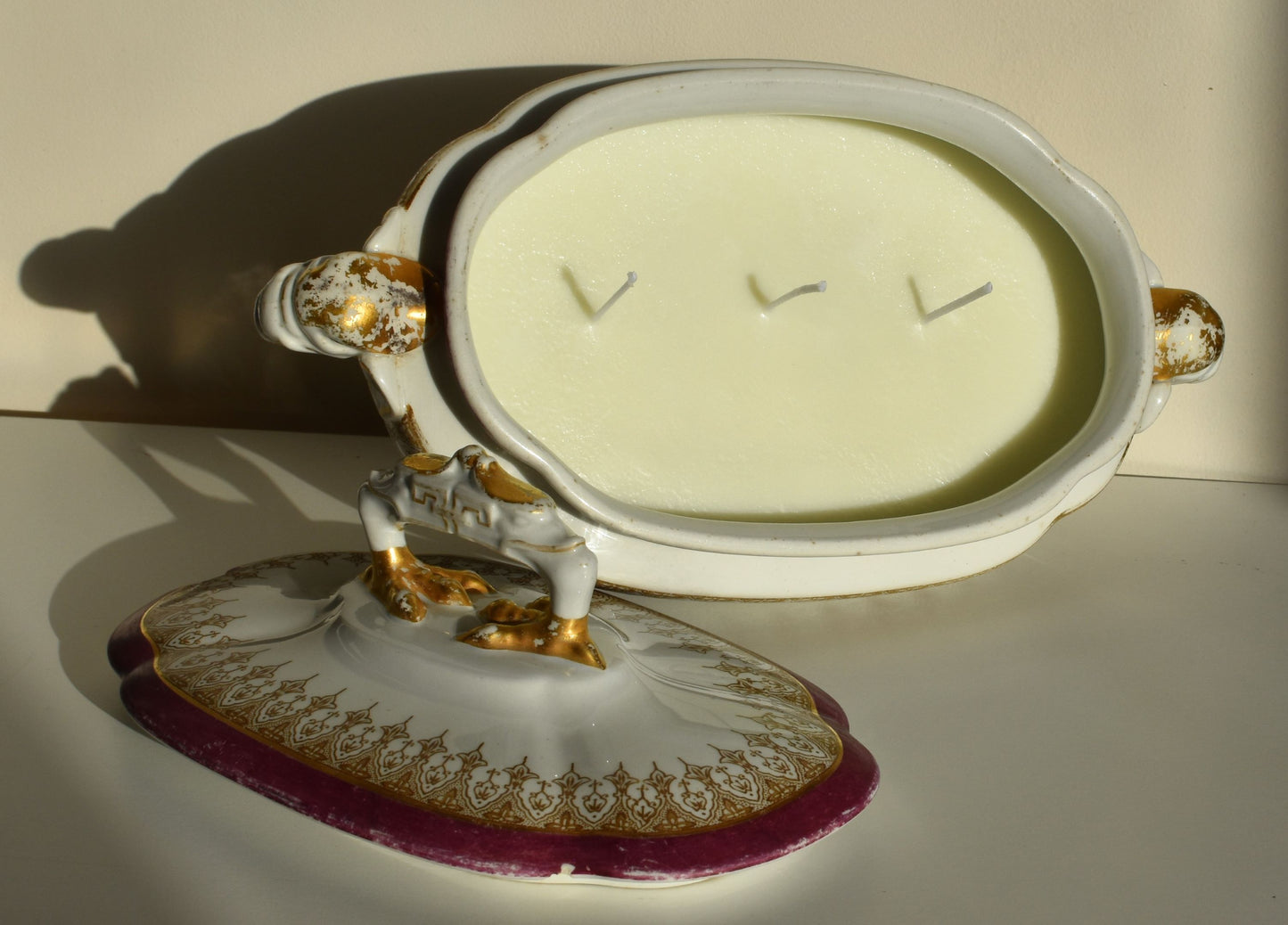 The tureen is filled with white wax and 3 wicks, making it a candle