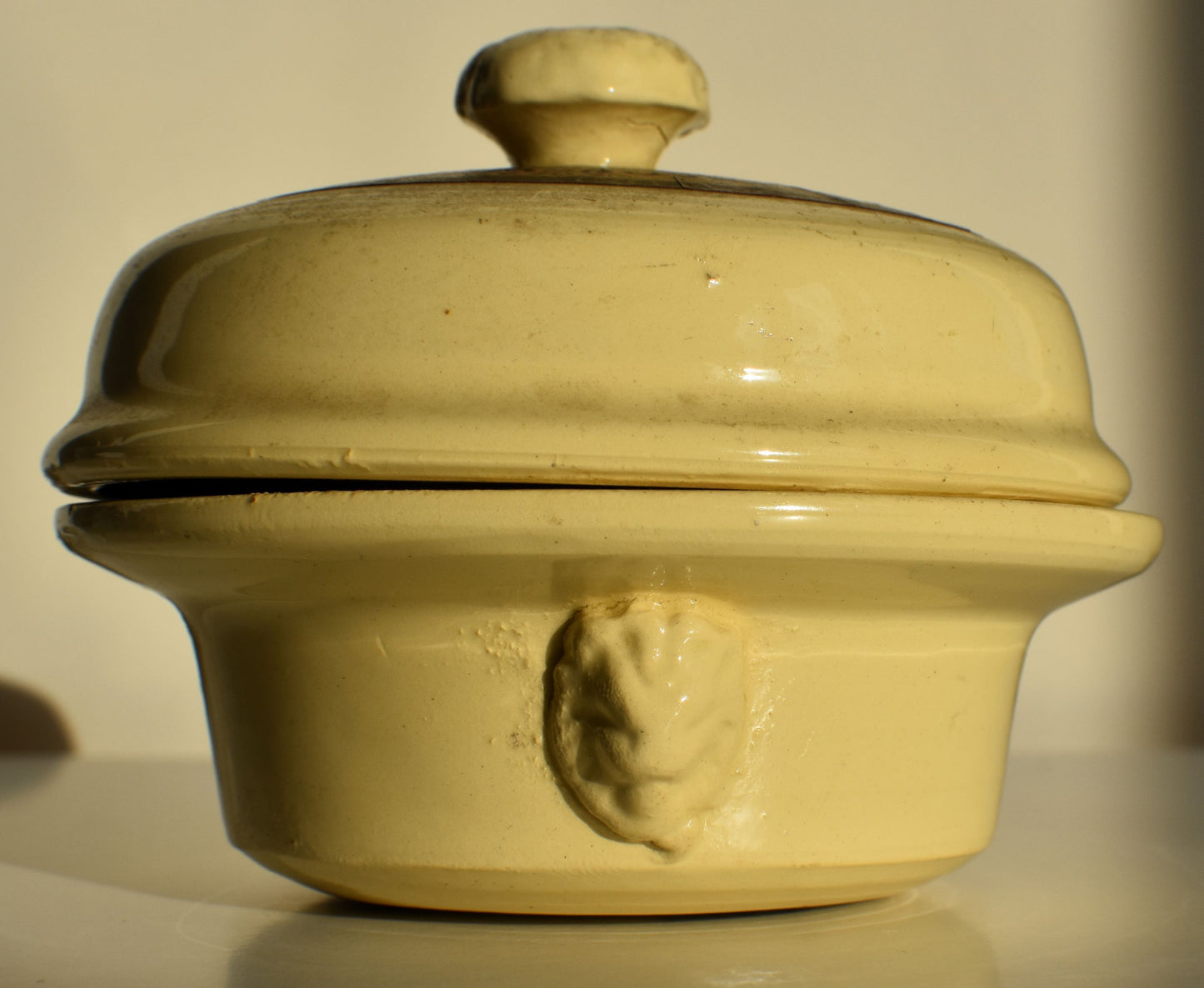 The side of the pot has a satyrs head in relief