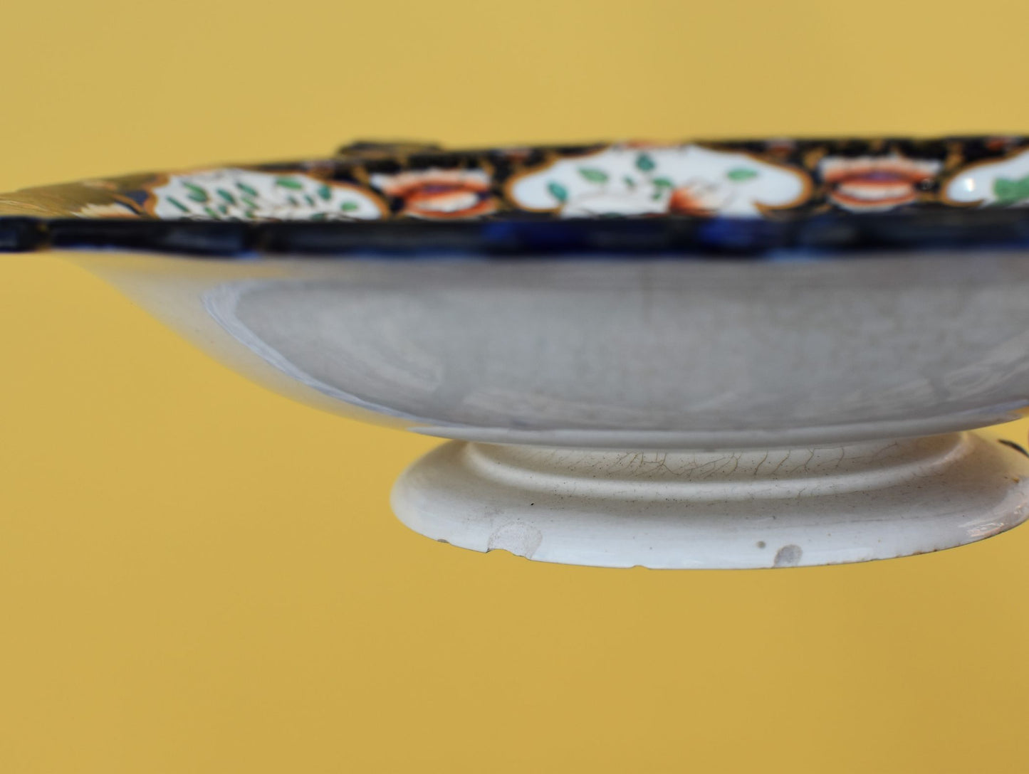 Decorative ceramic bowl with floral patterns on a yellow background