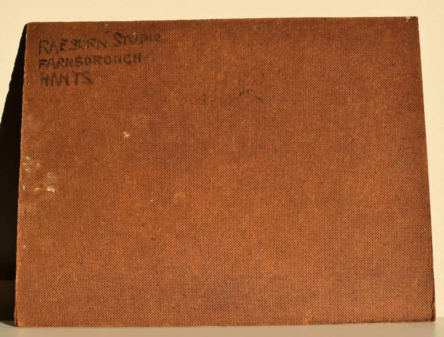 Brown textured book with 'Raeburn Studio' text on a beige background
