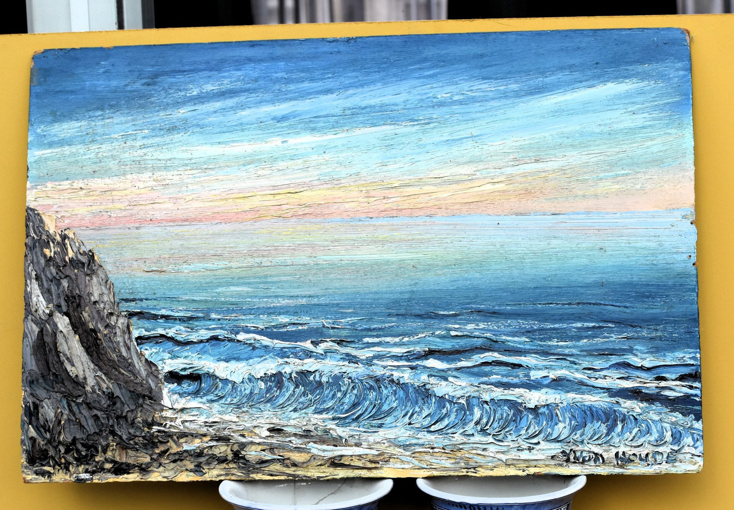 Painting of a coastal scene with waves and cliffs on a yellow background