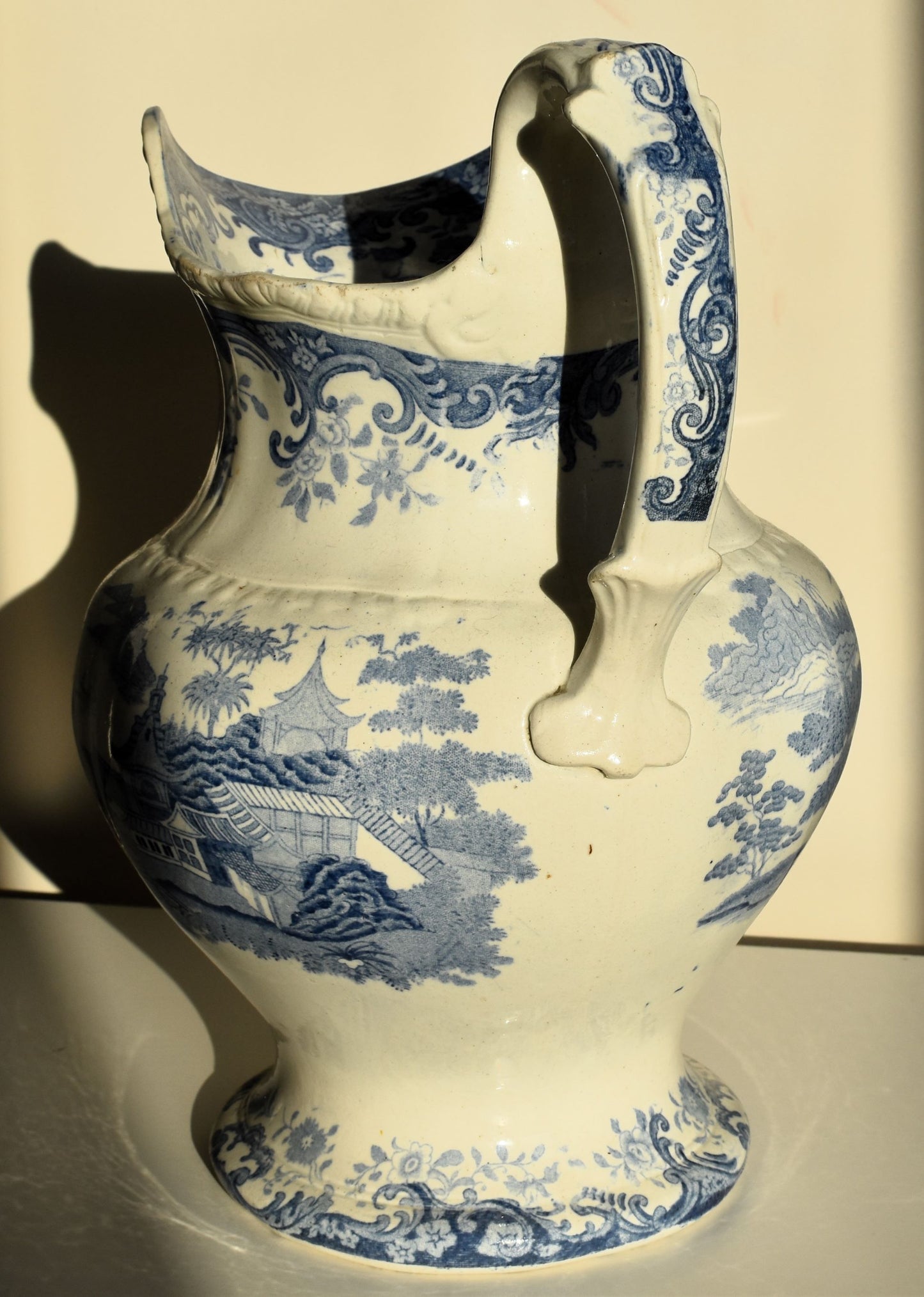 A large victorian pitcher jug decorated with chinoiserie scenes and florals