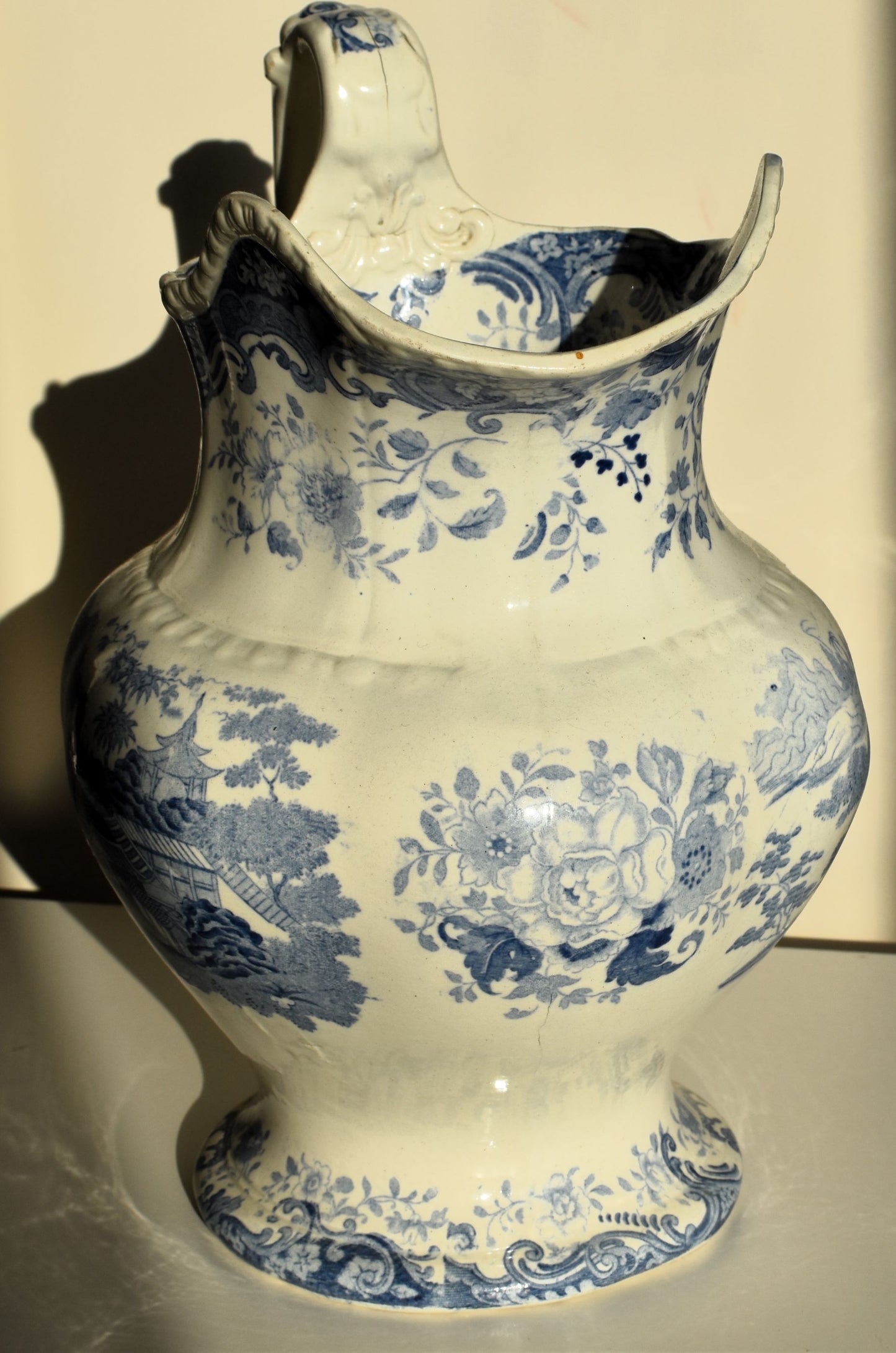 A large victorian pitcher jug decorated with chinoiserie scenes and florals