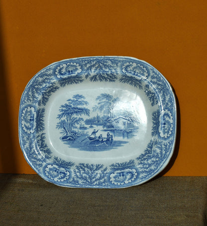 Blue and white patterned plate with scenic design on a brown background