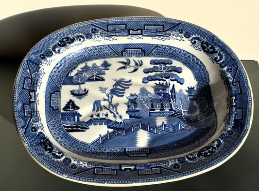 Blue and white decorative platter with intricate patterns on a black background
