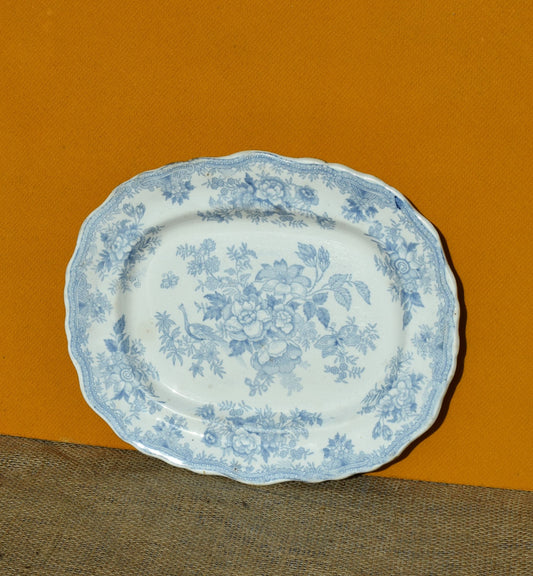 Decorative plate with blue floral pattern on an orange background