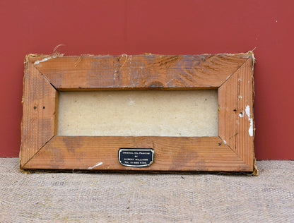 Worn wooden picture frame with a label on a textured surface and red background