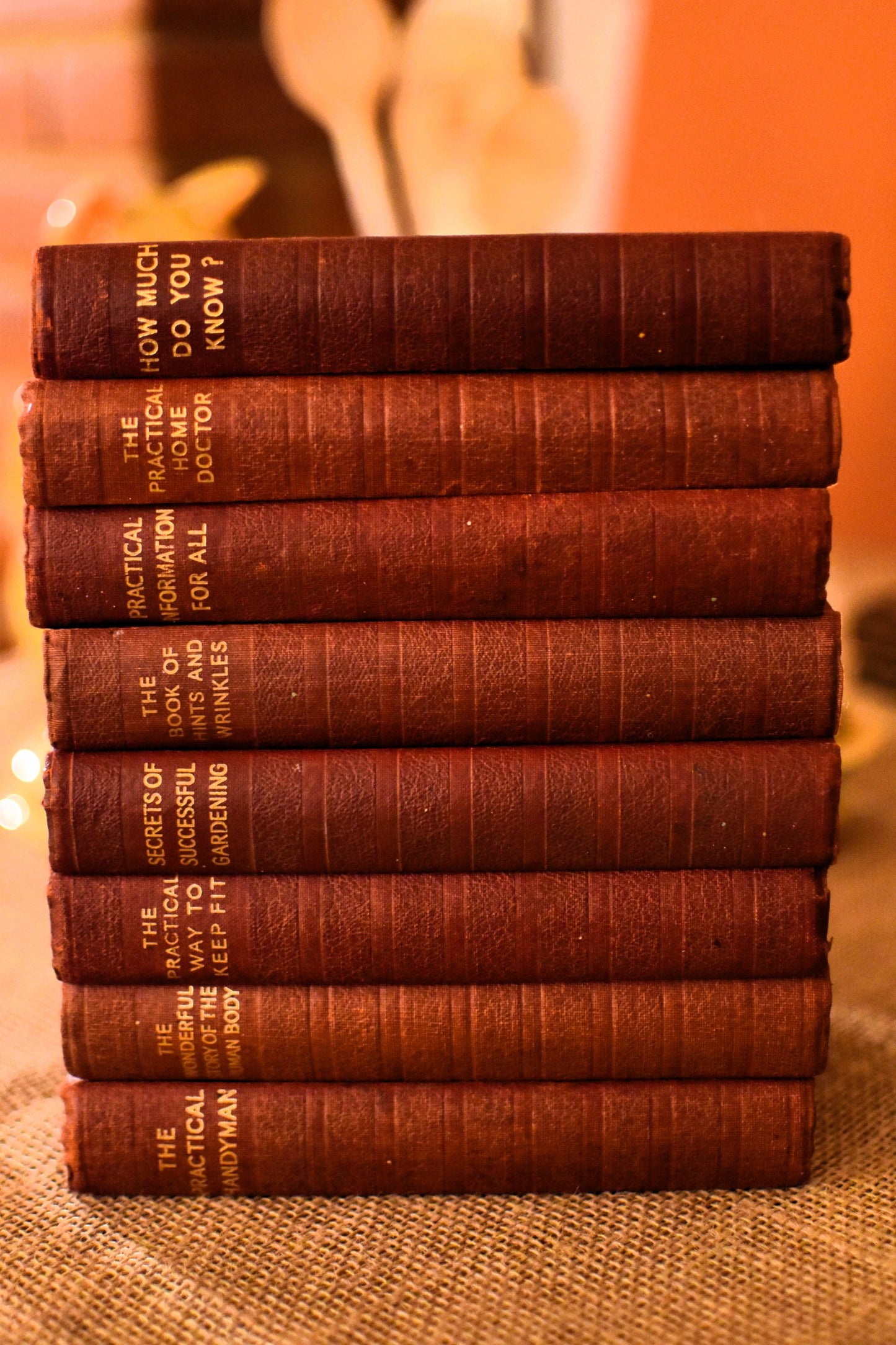 Stack of vintage books with visible titles on a textured surface