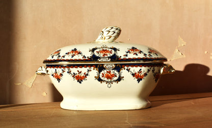 Decorative ceramic tureen with floral patterns on a wooden surface