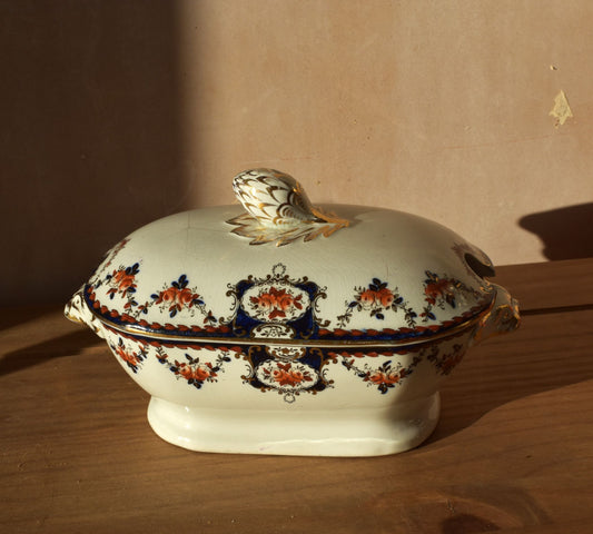 Decorative ceramic tureen with floral patterns on a wooden surface