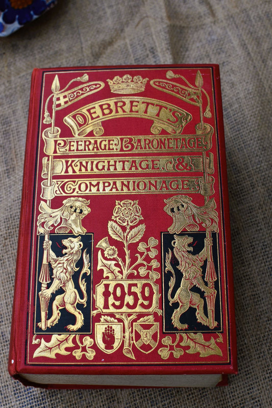 A large red and gold book called Debrett's Peerage, Baronetage, Knightage and Companionage