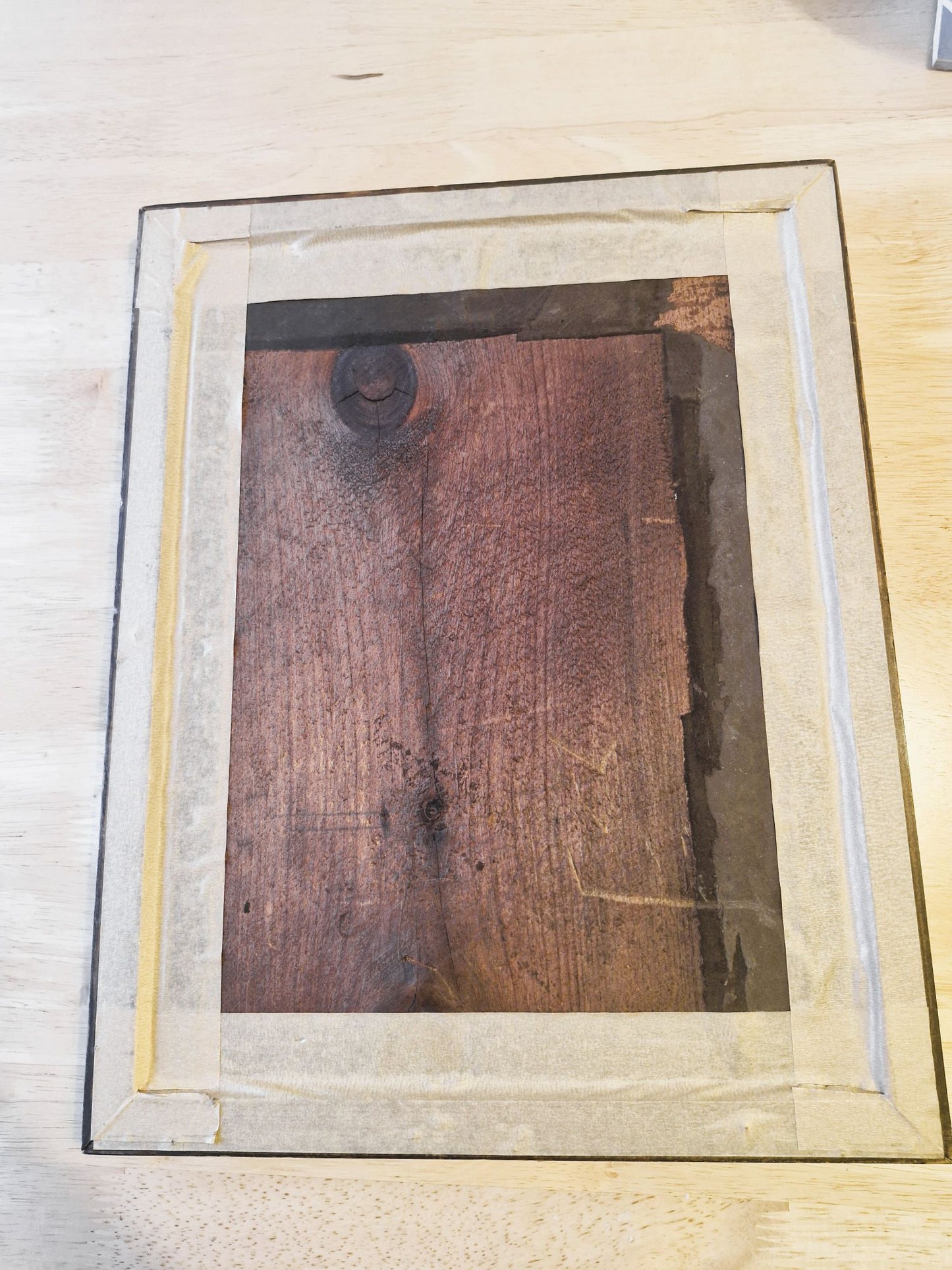 Wooden frame with glass on a light wooden surface