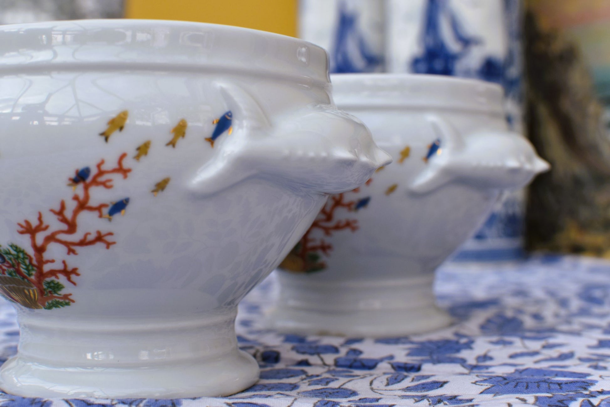 White ceramic bowl with fish and coral design on a floral tablecloth