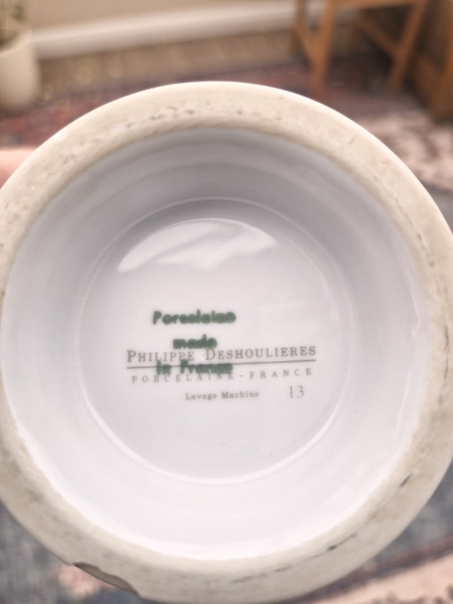 Close-up of a white container with 'porcelain made in france, Philippe Deshoulieres' branding