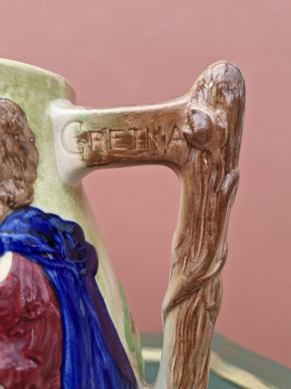 Decorative item with a figure and wooden handle, engraved with 'GRETNA'.