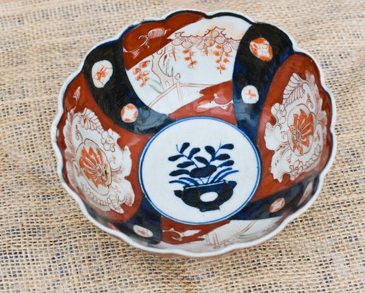 Decorative ceramic bowl with intricate designs on a textured fabric background