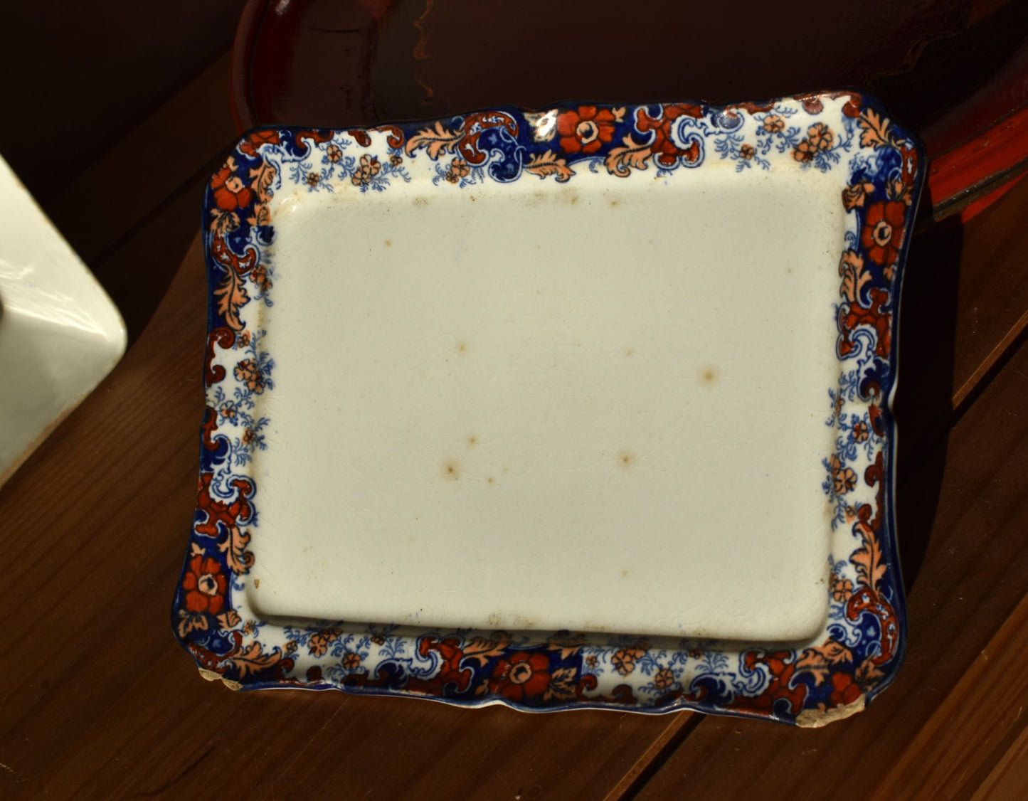 A white dish with a floral border on a wooden background