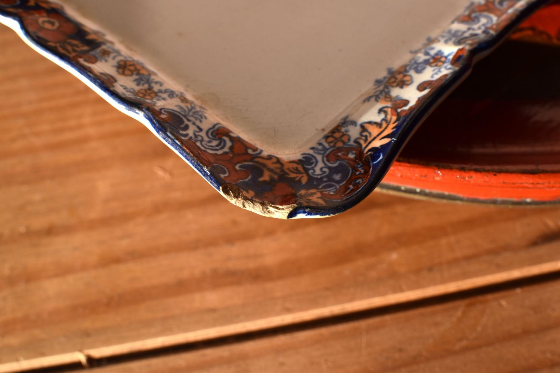 The corner of a floral dish is slightly chipped