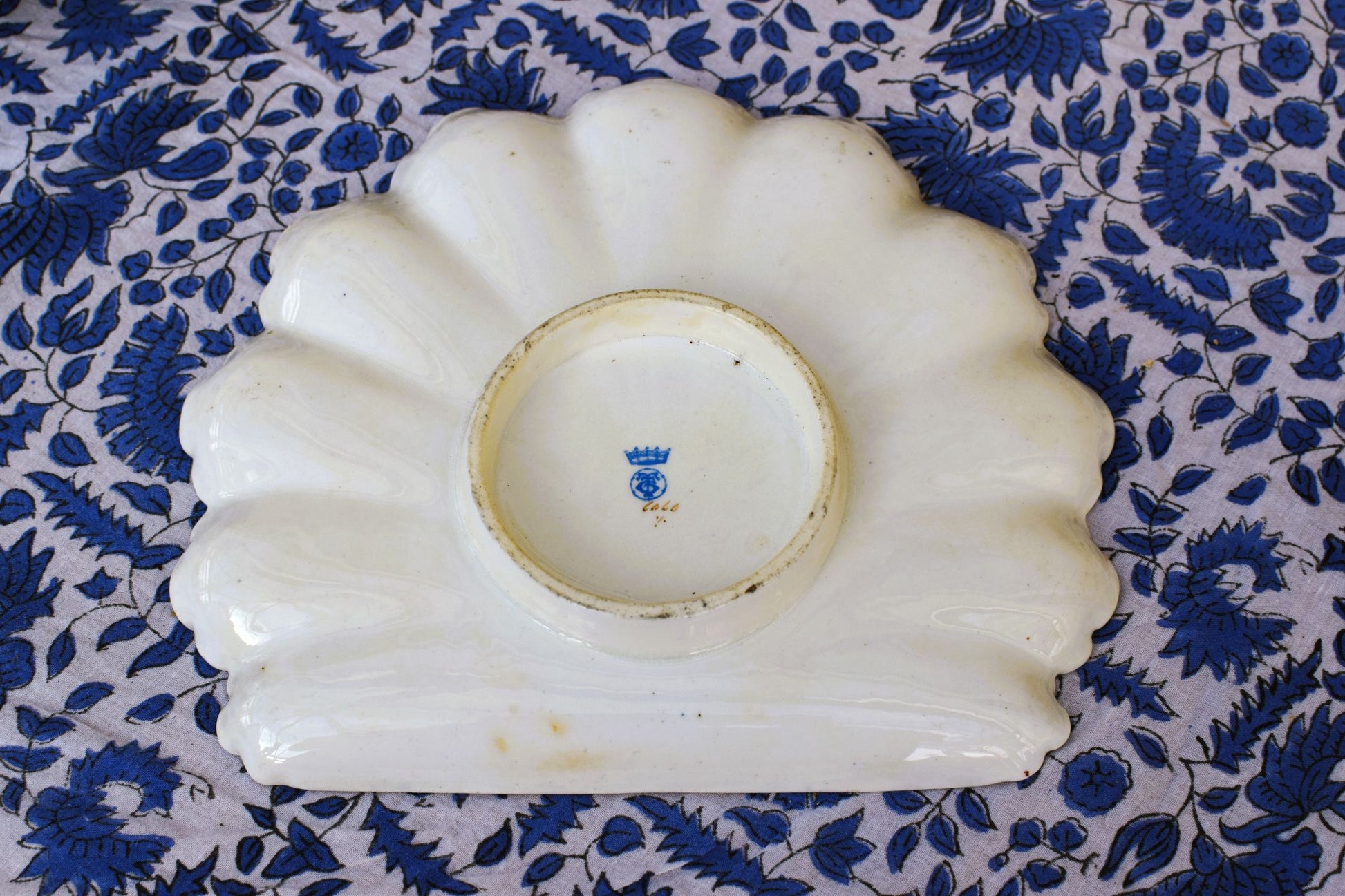 White ceramic dish with blue floral pattern on a blue floral fabric background