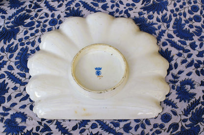 White ceramic dish with blue floral pattern on a blue floral fabric background
