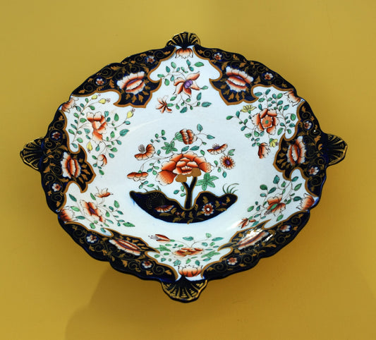 Decorative ceramic plate with floral and butterfly design on a yellow background