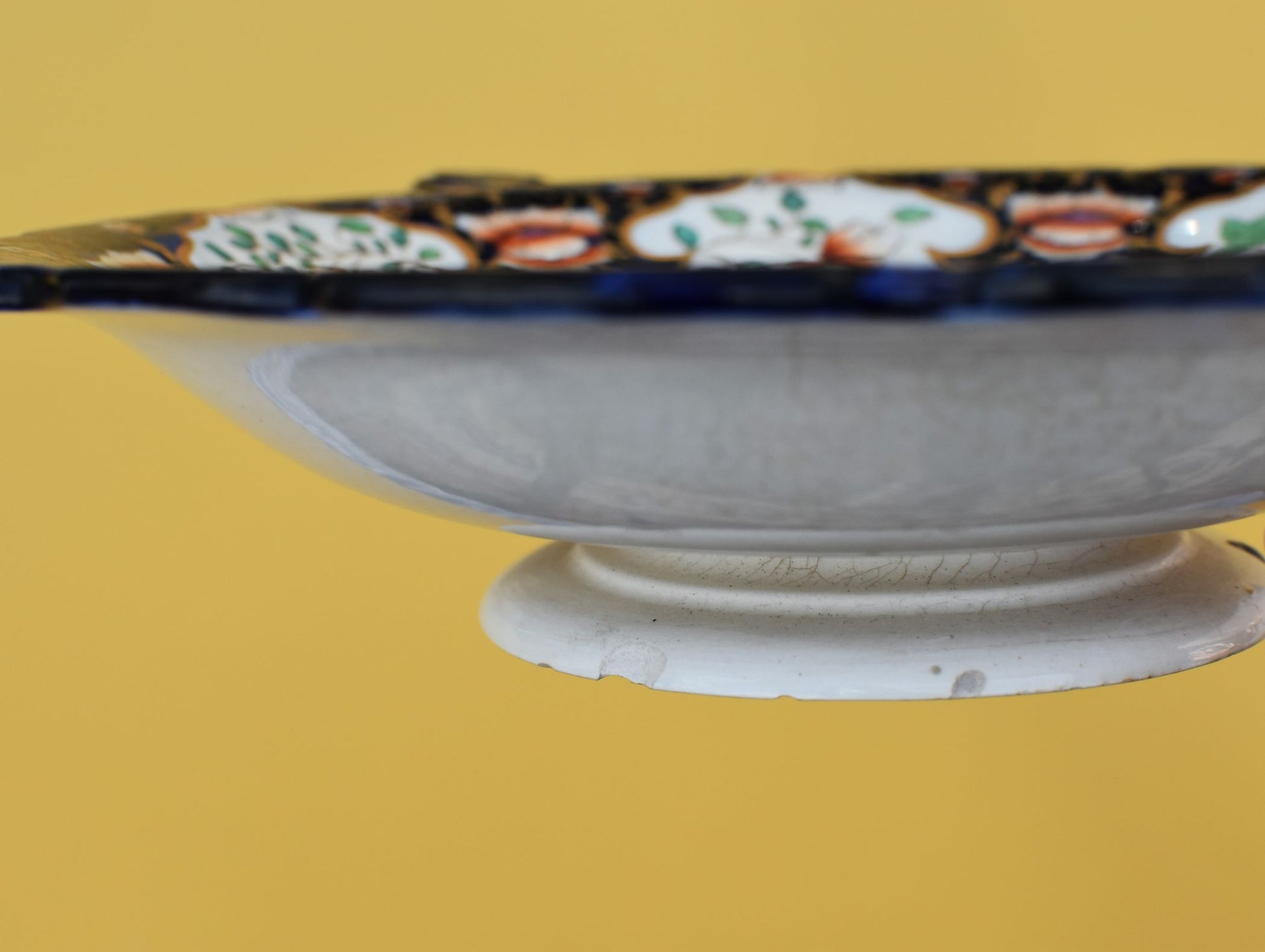 Decorative ceramic bowl with floral patterns on a yellow background