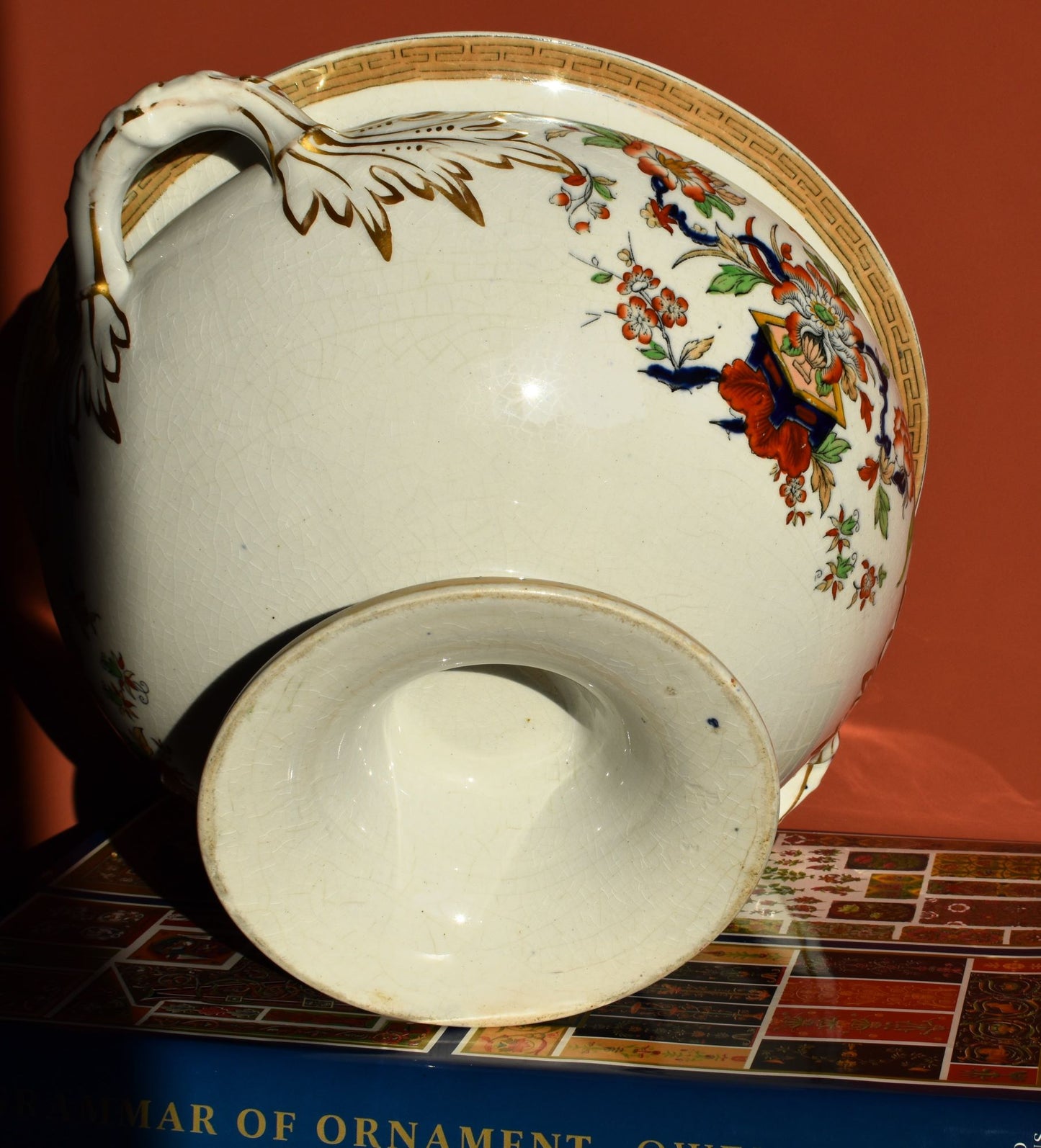 Decorative ceramic vase with floral and butterfly design on a red background