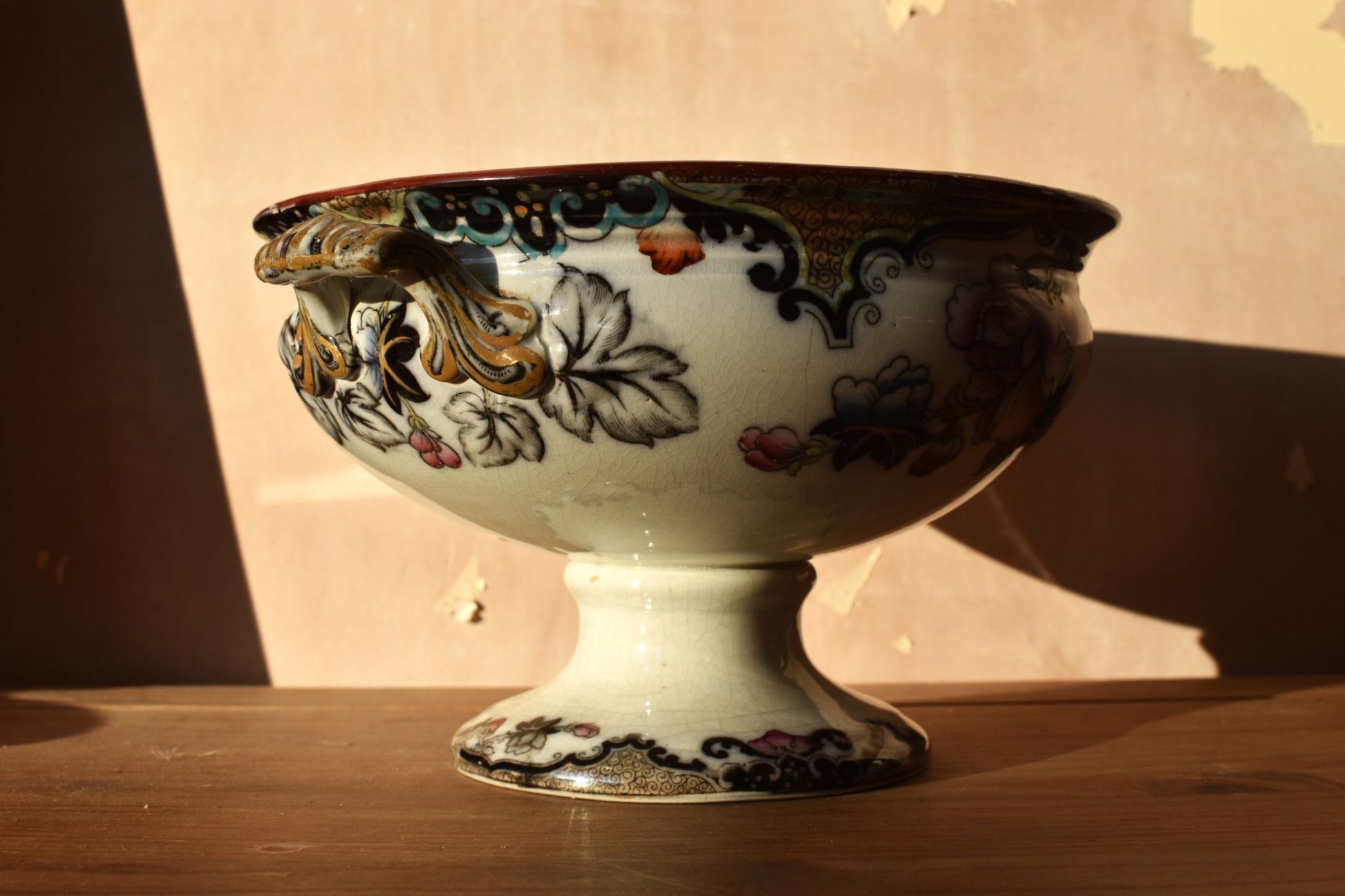 Art nouveau ceramic bowl with floral patterns on a wooden surface