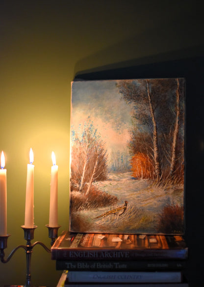 Oil painting depicting a pheasant in a wintery woodland. The painting is against a dark green background and lit by candlelight