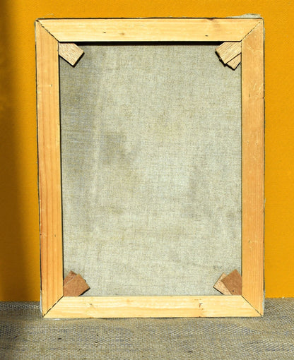 Wooden picture frame with a textured beige canvas against an orange wall.