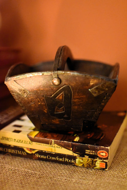 Decorative wood and metal square bowl with a chinese character on top of a book