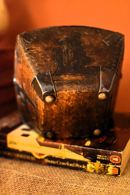Wooden box with metal clamps on top of a book