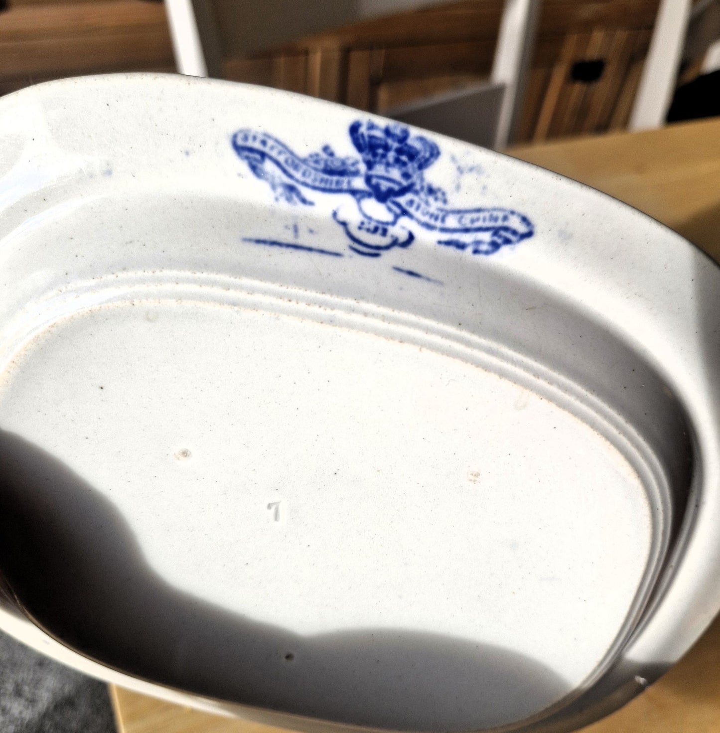 The makers mark of the plate says Staffordshire Bone China in blue on a white background