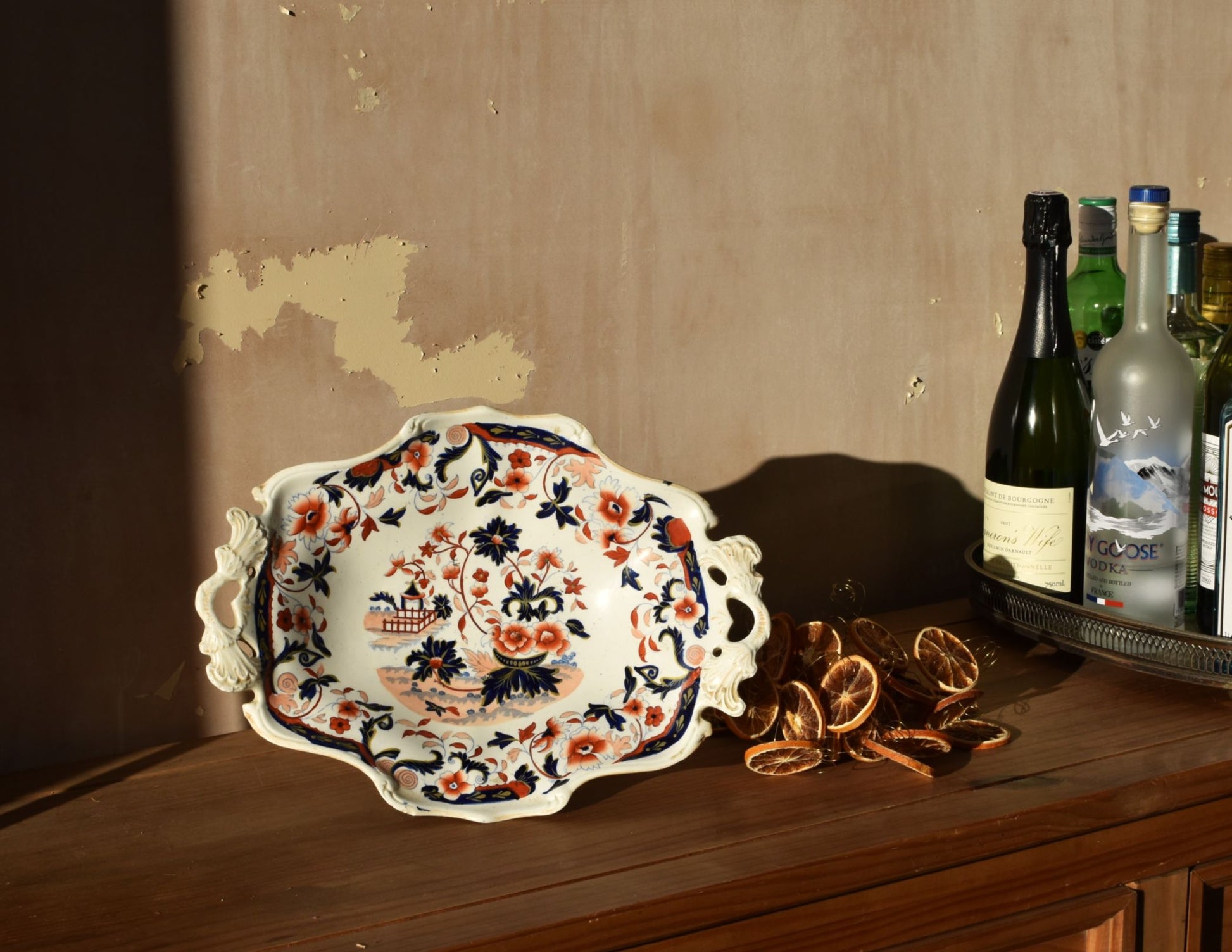 a white and floral dish againt a distressed plaster wall