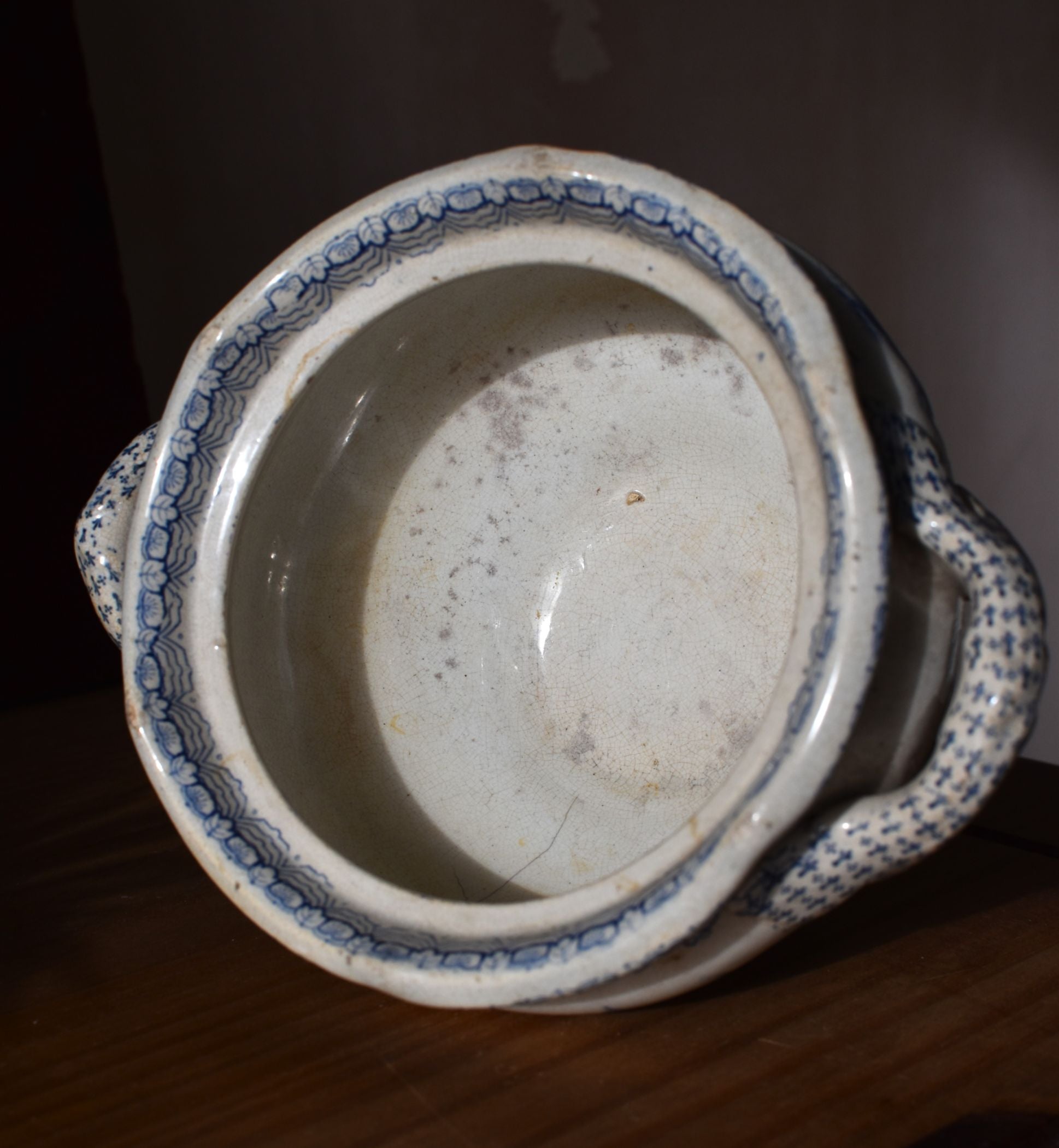 Vintage ceramic pot with blue decorative patterns on a dark background
