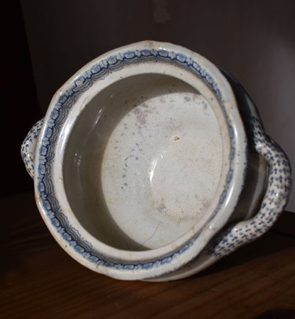 Vintage ceramic pot with blue decorative patterns on a dark background