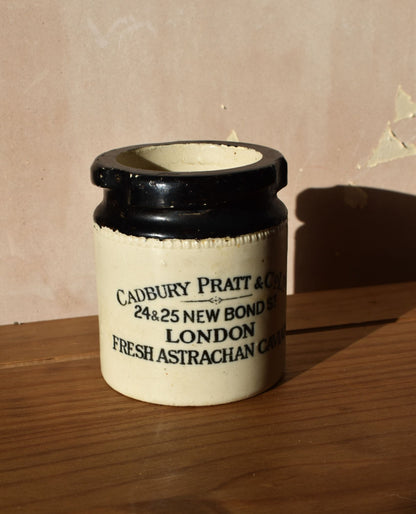 Vintage-style jar with black lid on a wooden surface