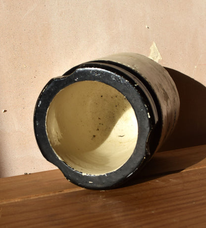 Cylindrical metal component with black exterior on a wooden surface
