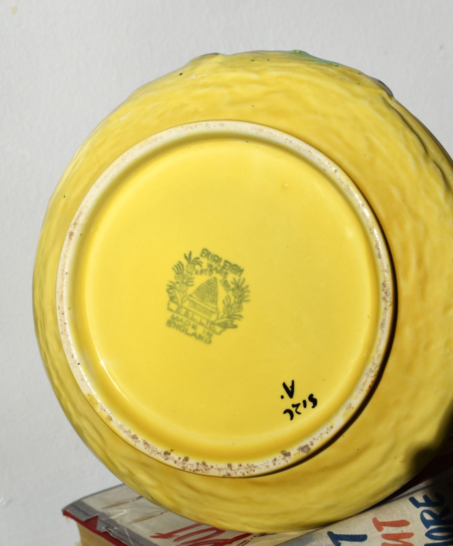Yellow ceramic plate with a logo and text on a white background