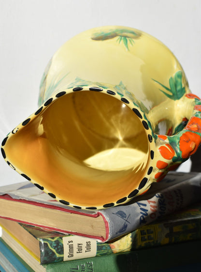 Decorative ceramic jug with floral patterns on a stack of books