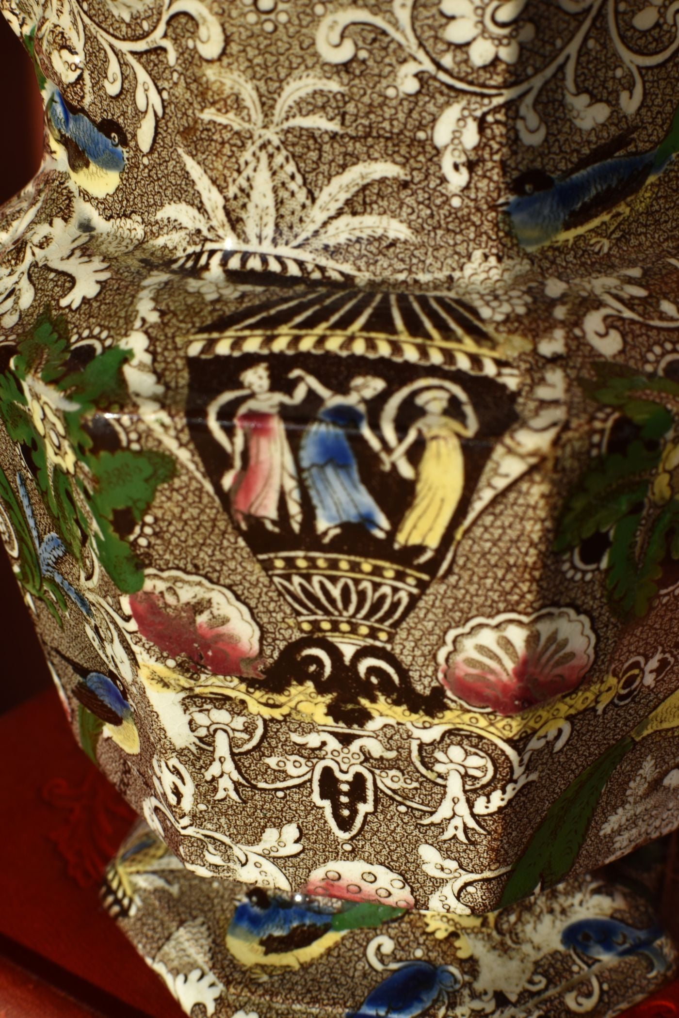 Decorative fabric with intricate patterns and figures on a brown background