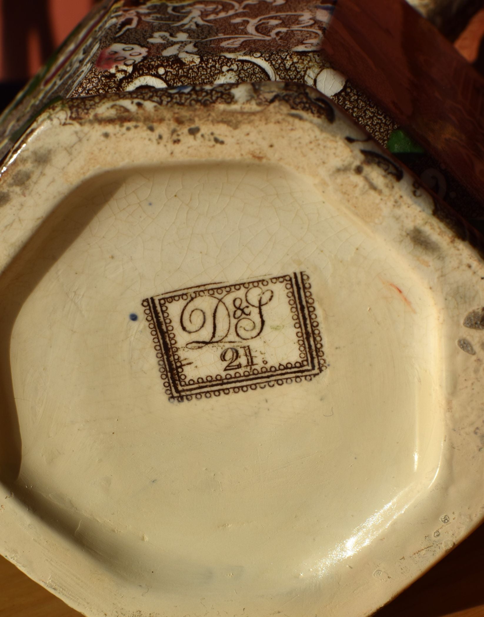 Decorative ceramic dish with a logo and number on the base