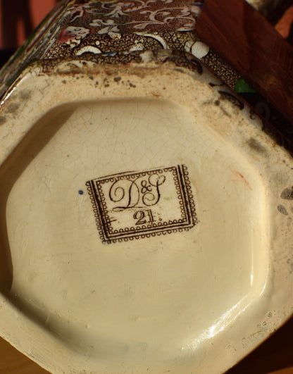 Decorative ceramic dish with a logo and number on the base